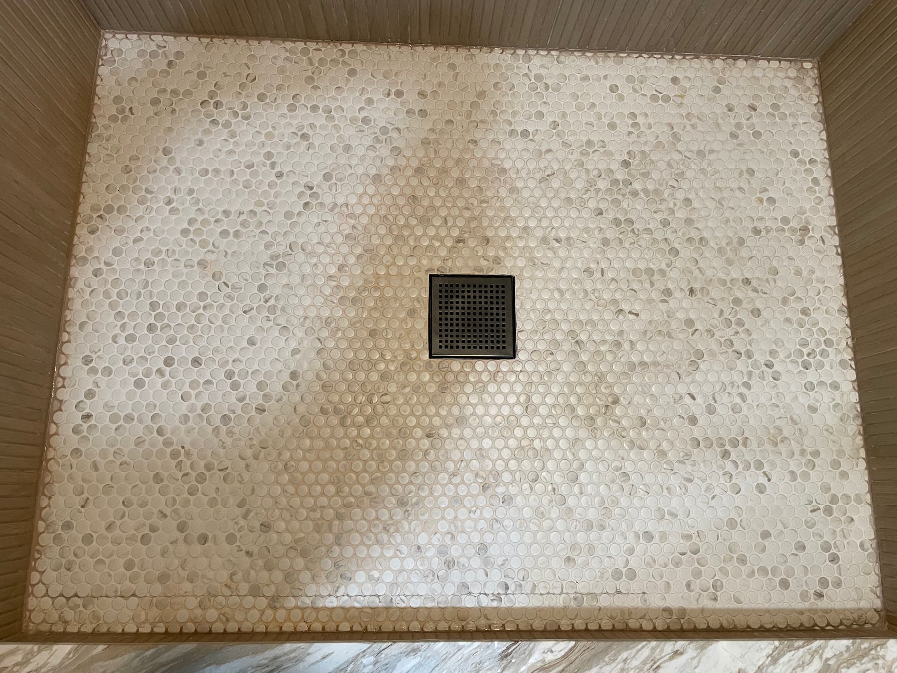 Before repair: widespread cracking across a penny-round tile shower floor in Highland Park, Illinois